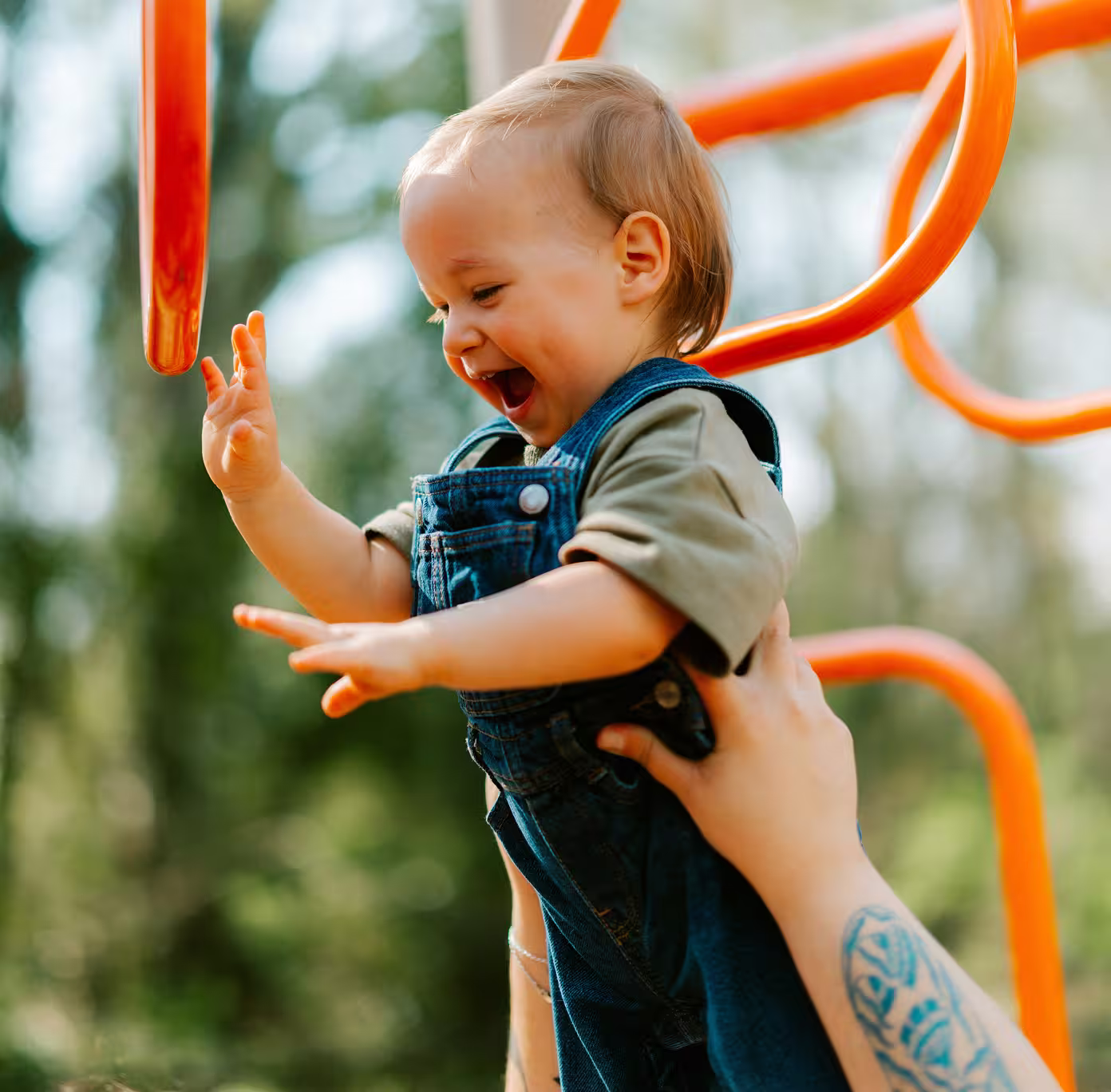 Joyful toddler playing on an orange playground structure